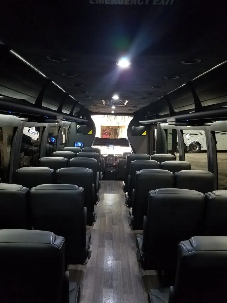 Leather seats and wood floor inside a B & W mini coach at night